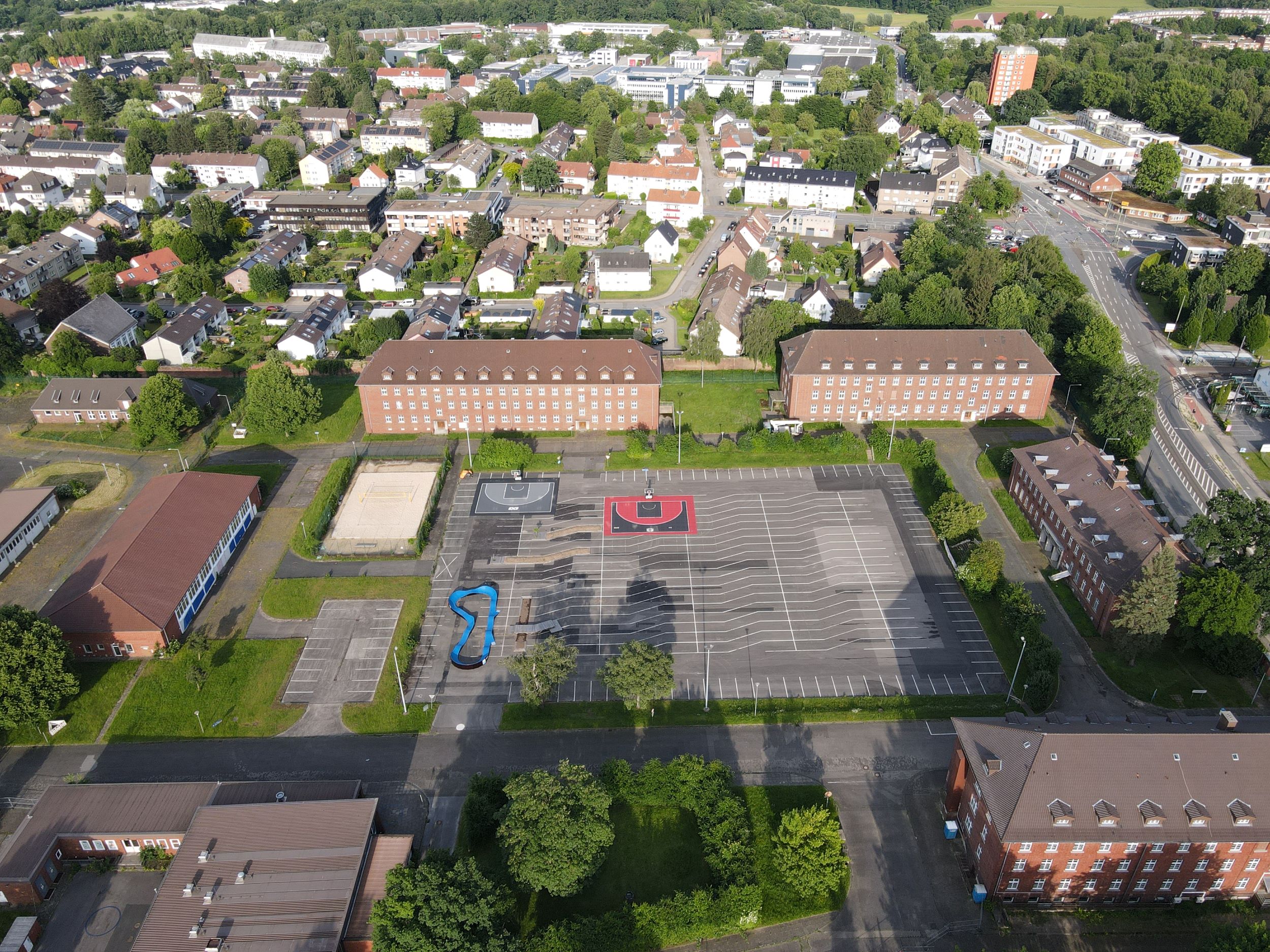 Auf dem Drohnenfoto sieht man den ehemaligen Exerzierplatz mit den neuen Sportangeboten Beachvolleyball, Basketball und Pumptrack sowie den kleinen 